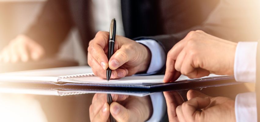 يوقع المحترف على مستند على نسخة ورقية.