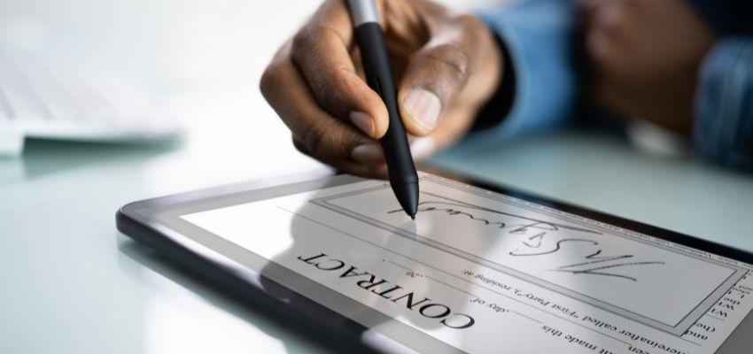 Une personne qui signe un document commercial avec une signature pp.