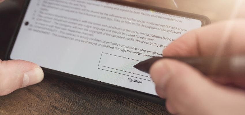 A person signs a digital agreement using an electronic signature.