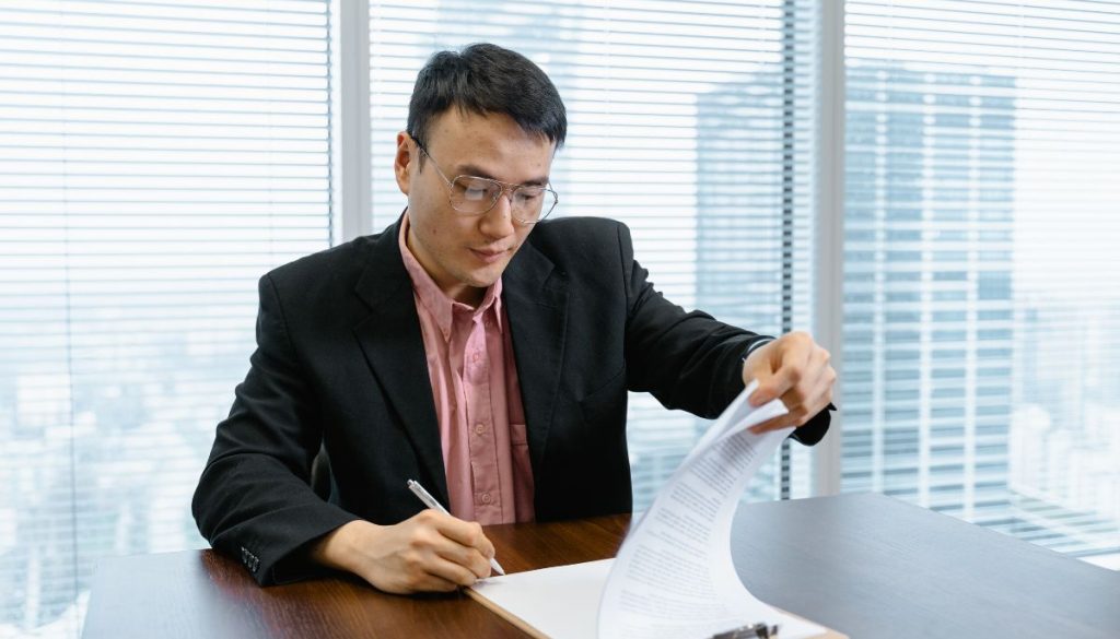 The businessman signs a business agreement.