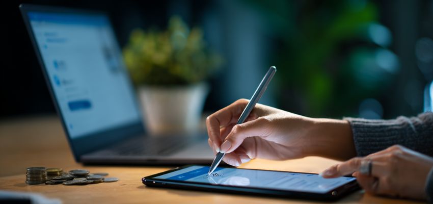 Eine Geschäftsfrau unterzeichnet einen digitalen Vertrag mit Hilfe eines digitalen Signierdienstes.
